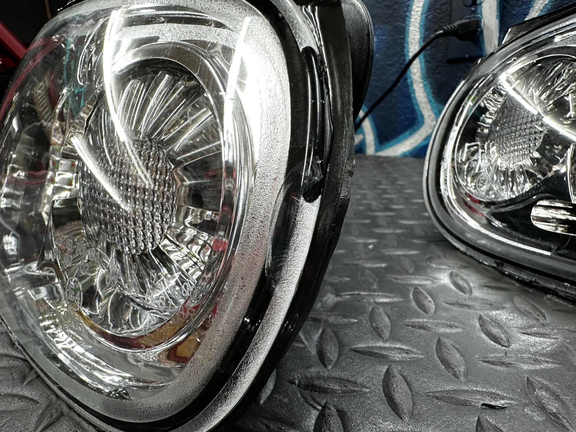 Angled close-up of the clear lens and housing edge on the as-is NA Miata tail light set