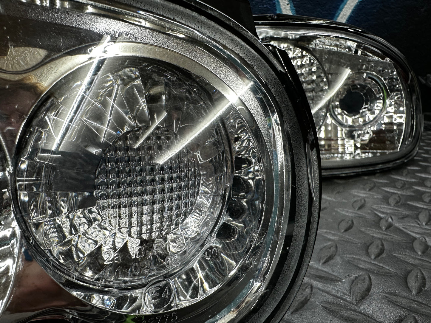 Detail view of the round lamp section of the NA Miata clear tail light showing marks on the inside of the lens