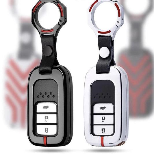 Two car key fobs with black and white designs on a blurred background.